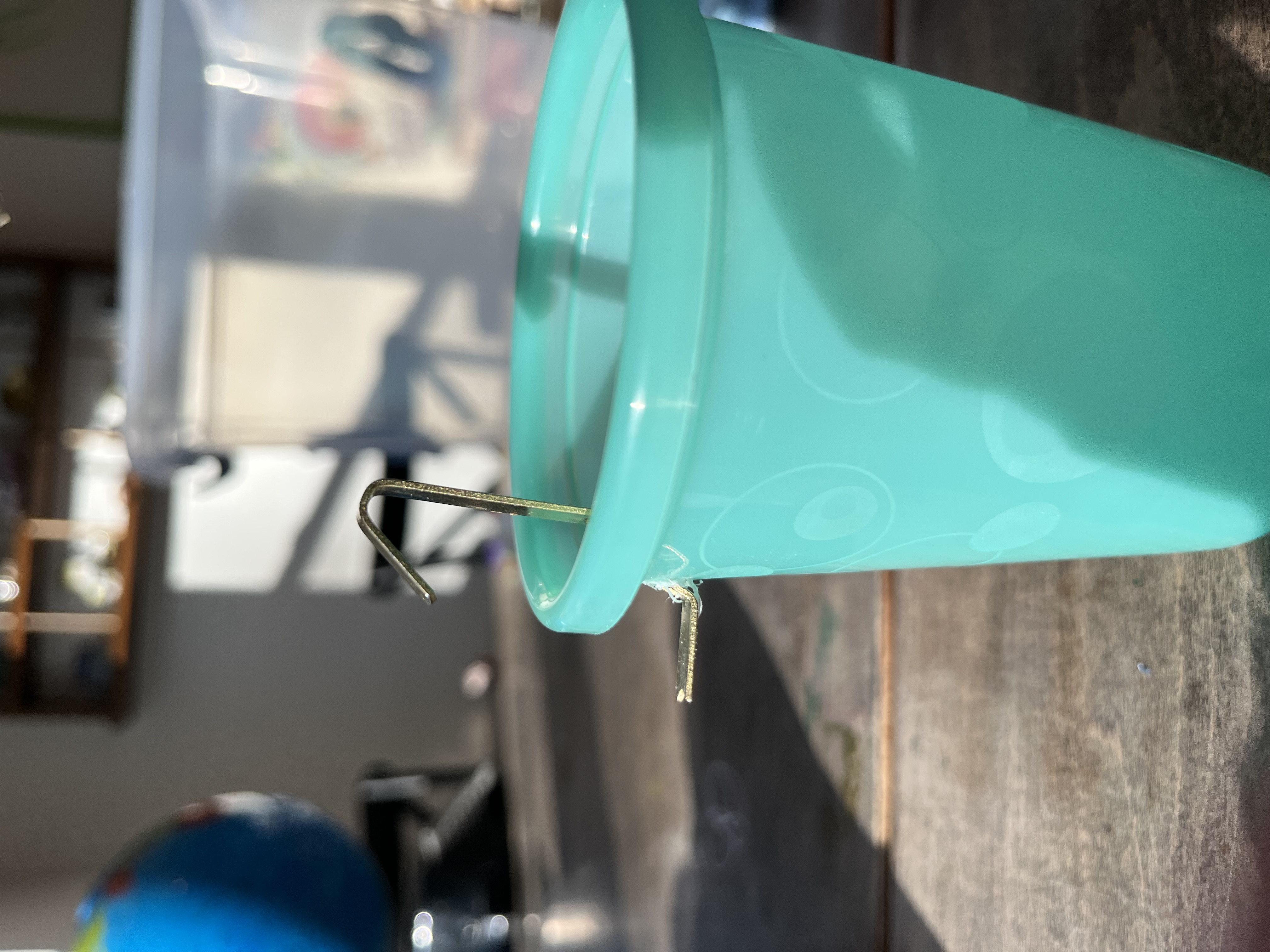 Pushing the hook through the hole in the cup